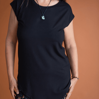 Haut noir à manches courtes avec pointe asymétrique fait au Québec, Canada.